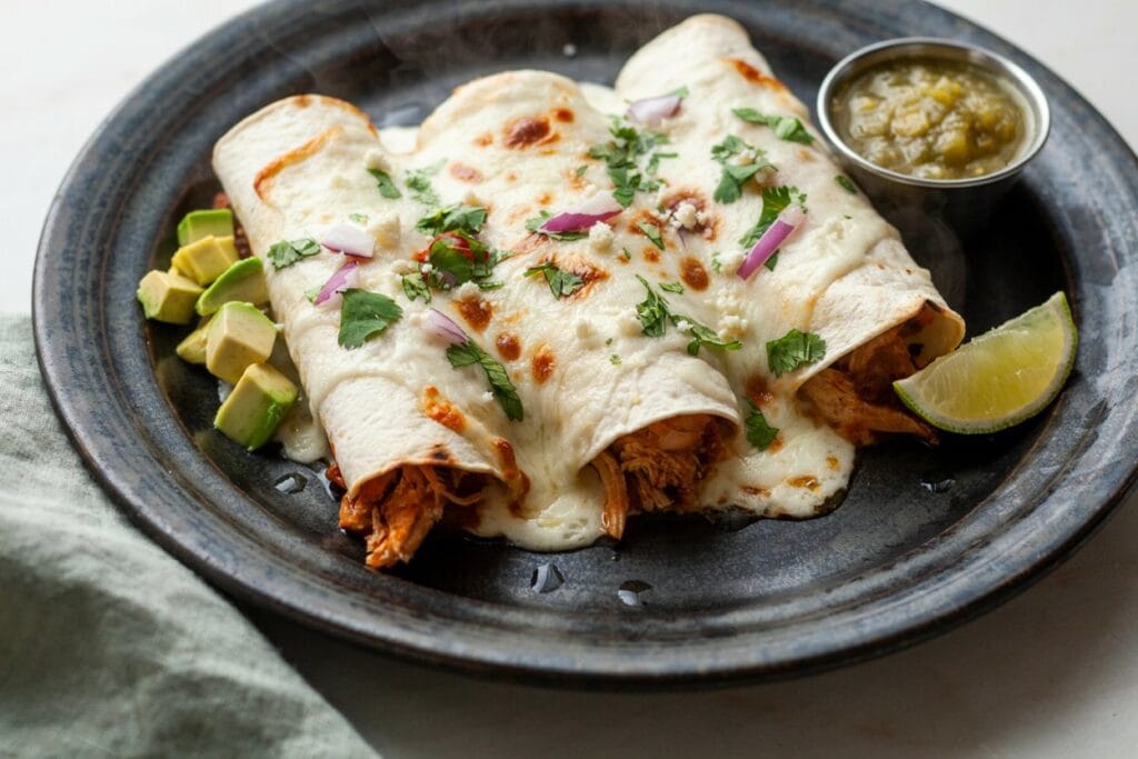 White Chicken Enchiladas covered in melted cheese and garnished with cilantro.